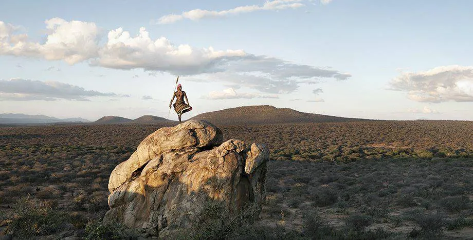 Photo d'une personne méditant sur un rocher avec une vue panoramique.